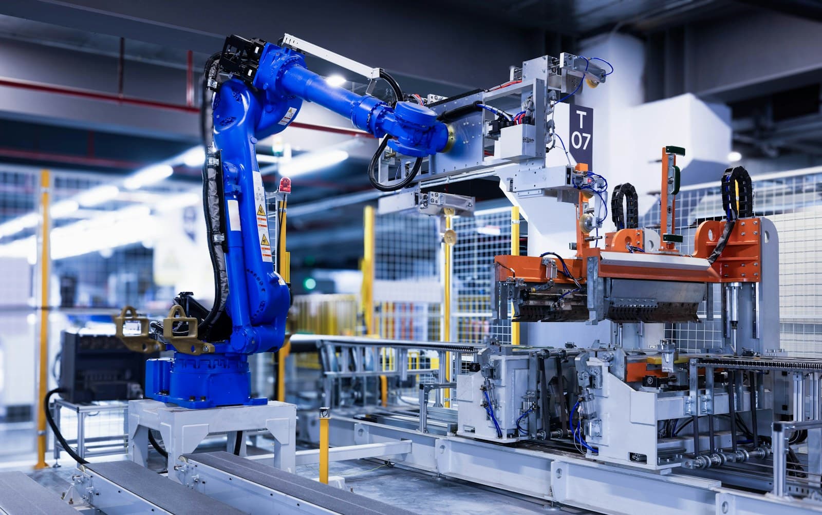 An industrial robotic arm handling a panel on a production line